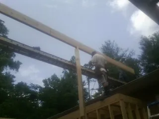 Carpenter setting a ridge beam over a new addition frame — Ice Dam Removal by Roofing Brothers in Glen Richey